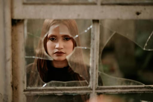 a woman looking upset that her window is broken