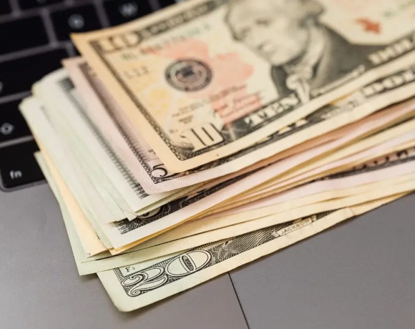 Stack Of Cash Money On Laptop